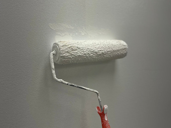 Farbroller an einer weißen Wand